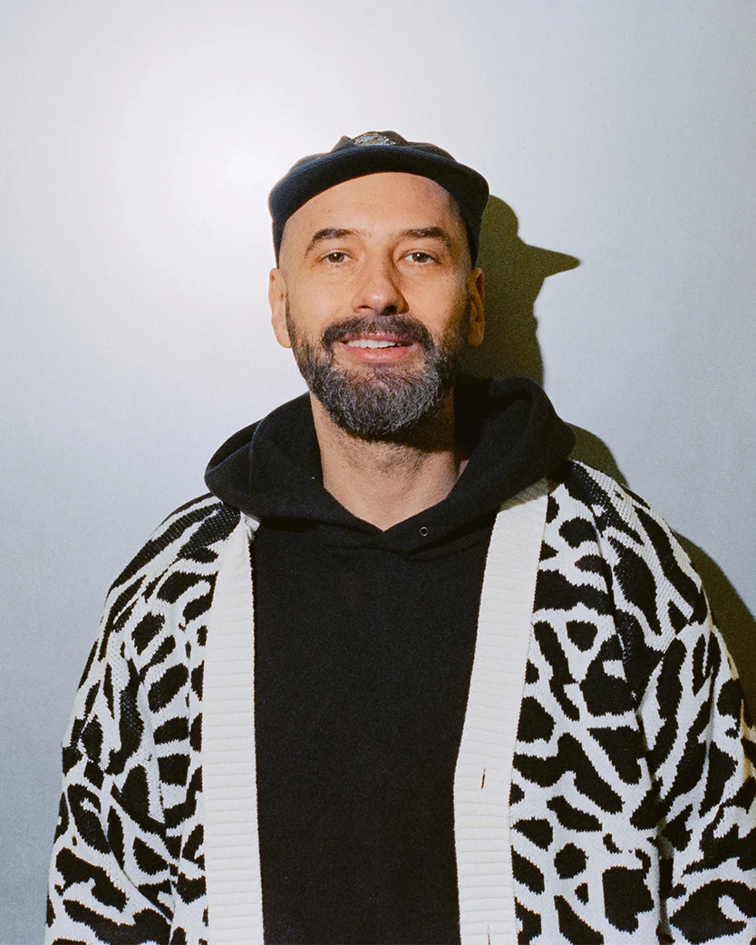 Moritz Pommer in a patterned cardigan, smiling